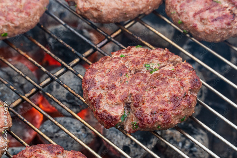 A beef burger grill cooking close up A beef burger grill cooking close up