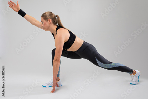 fitness trainer shows exercises for the body on a gray background