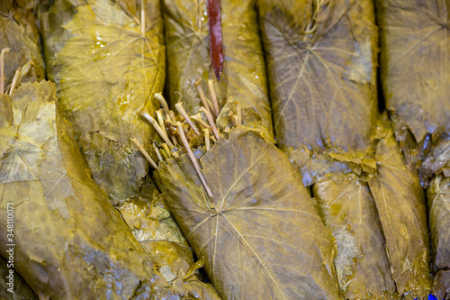 Pickled grape leaves close-up. Grape leaves for preparation of traditional oriental dishes and snacks on counter of oriental bazaar photo