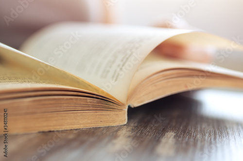 Vintage close up of an old open book with yellow pages. Avid reader, bookworm concept