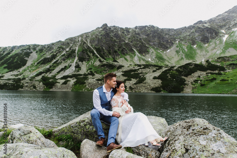 Beautiful bride and groom hug and kiss in the mountains. Wedding photo session in the mountains.