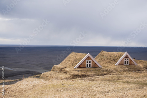 Beautiful Icelandic scenery, small house in remote location with sea in the background and black sand due to volcanic eruptions. Second photo in the series.