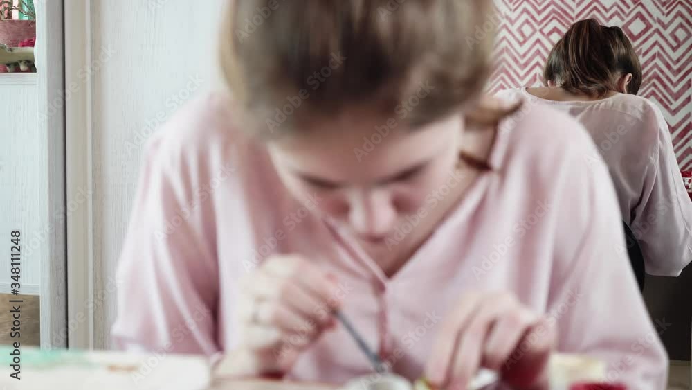 Front view of girl drawing at table and her reflection in mirror. Front view of girl drawing at table and her reflection in mirror.