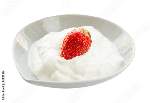 Morning breakfast with greek yogurt and and whole fresh strawberry on top isolated on white background. Side view.