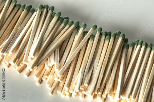 Heap of matches with green heads on a white background.