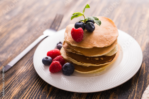 Homemade american pancakes with fresh blueberry and raspberries. Healthy morning breakfast. Rustic style