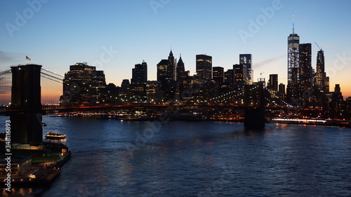 Panorama view of Manhattan's skyline at dusk, city lights.