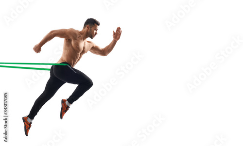 Shirtless man running in place using resistance band.