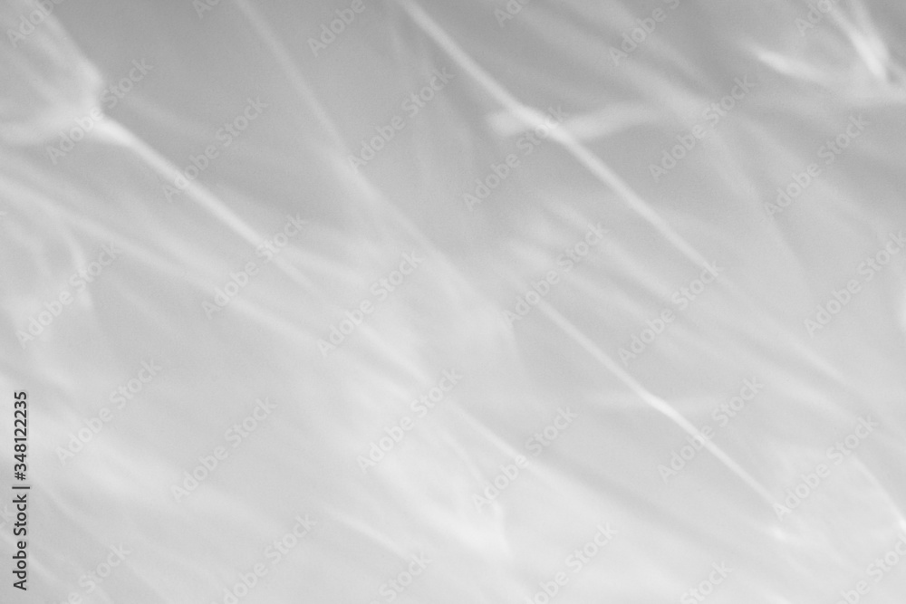 Fototapeta premium Blurred water texture overlay effect for photo and mockups. Organic drop diagonal shadow and light caustic effect on a white wall. Shadows for natural light effects