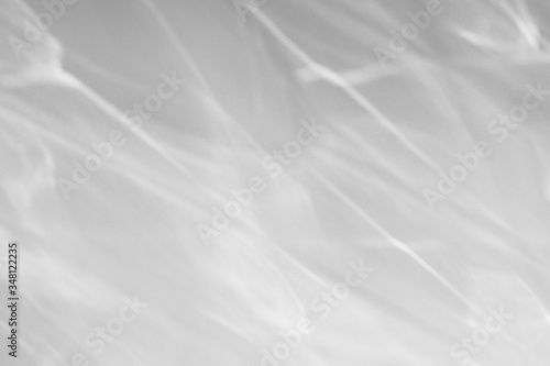 Blurred water texture overlay effect for photo and mockups. Organic drop diagonal shadow and light caustic effect on a white wall. Shadows for natural light effects