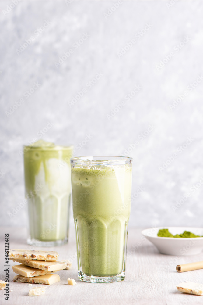 Glasses of matcha latte with coconut milk and white chocolate on wooden and marble background Glasses of matcha latte with coconut milk and white chocolate on wooden and marble background