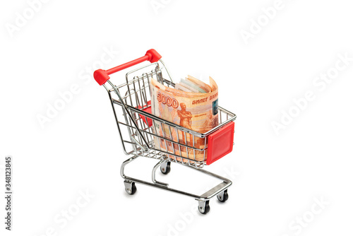Five thousand Russian rubles bills in a small shopping cart isolated on a white background