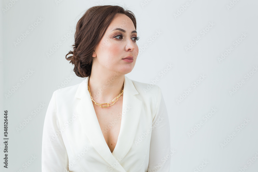Girl in white suit with make-up posing on a white room. Fashion style body length studio portrait. Elegant fashionable woman. Girl in white suit with make-up posing on a white room. Fashion style body length studio portrait. Elegant fashionable woman.