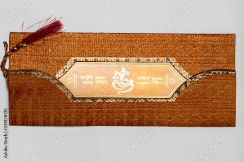 A beautiful wedding card on a hand made textured paper with lord ganesha and a mantra written in sanskrit language