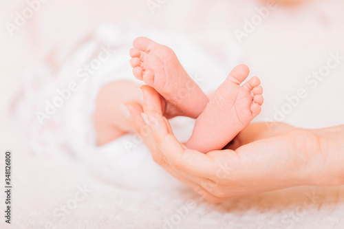 Baby feet in mother hands. Newborn baby's feet on female shaped hands closeup. Mom and her child. New family concept. Beautiful conceptual image of Maternity.