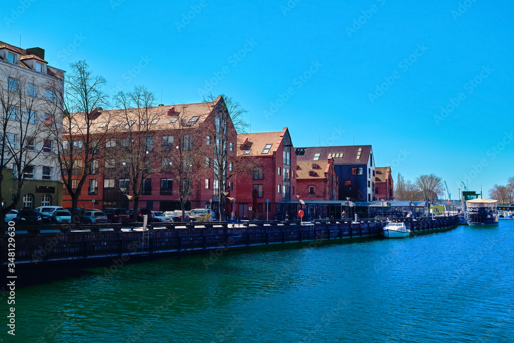 Jetty for boats and yachts in Klaipeda, Lithuania, on sunny day. Beautiful view of vessels and fachtwerk and red-brick houses