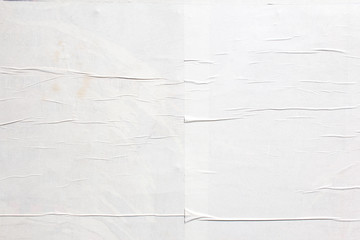 White crumpled wavy paper poster glued on billboard texture background. Copy space for text.