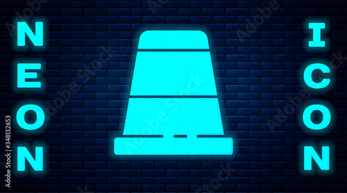 Glowing neon Thimble for sewing icon isolated on brick wall background. Vector