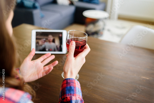 Woman drinking wine online with male friend