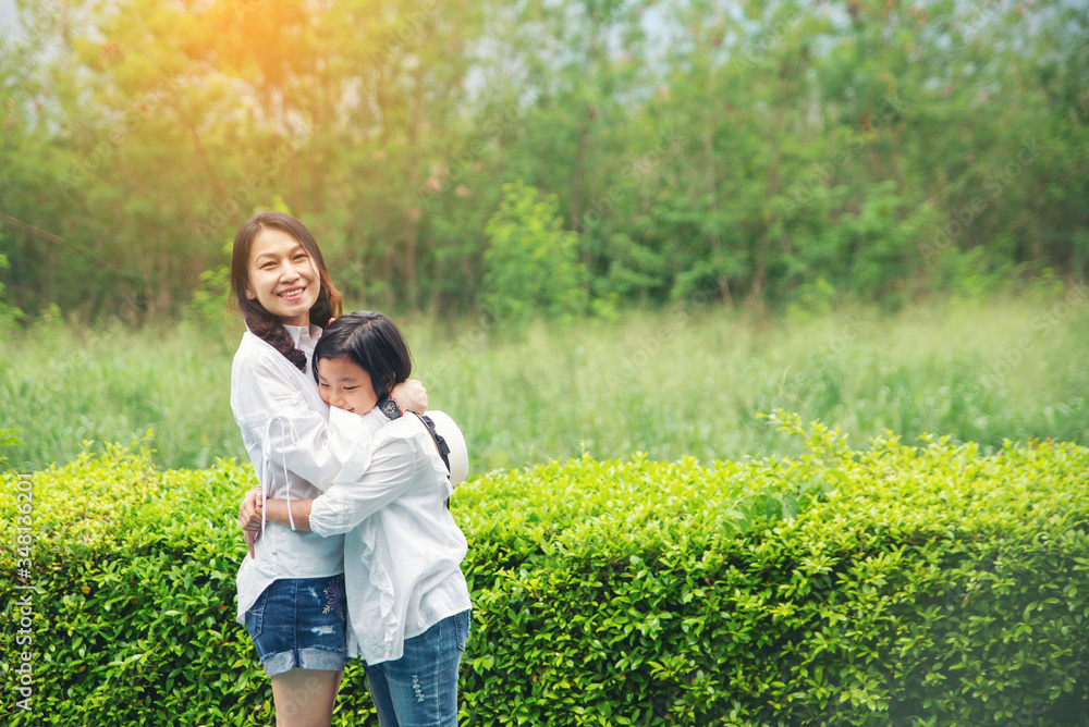 Fototapeta premium Asian mother and Kid playing together in nature park. Mother and Daughter greeting and hug, I Love you mom. Happy family in mother's day concept.
