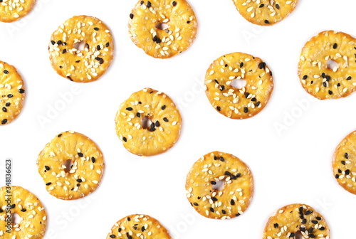 Baked pretzels with black and white sesame seeds, savory snacks isolated on white background, top view