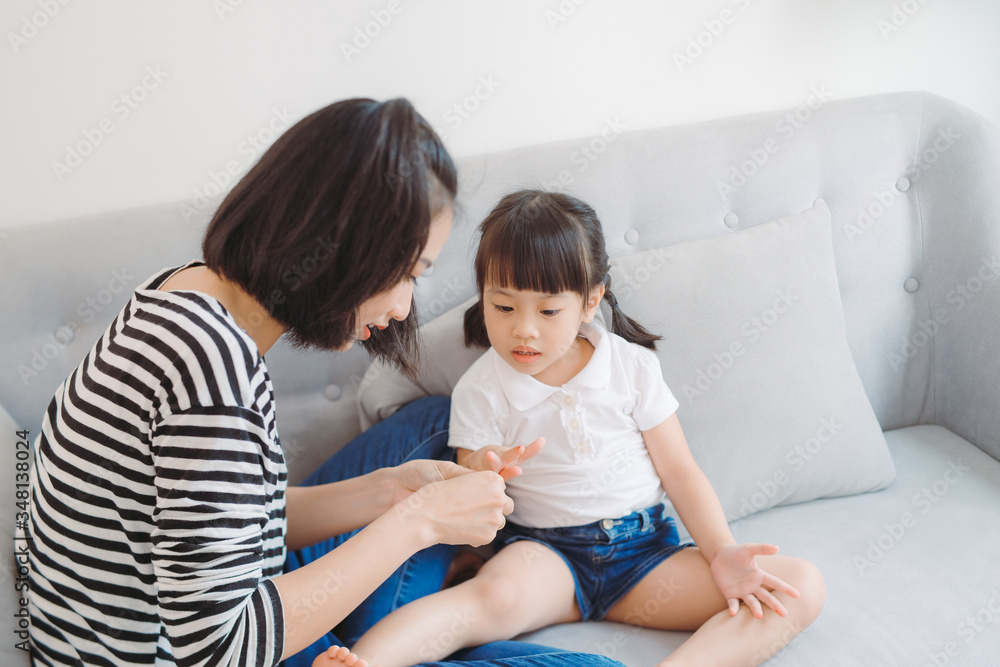 Mother and daughter painting their finger nails with polish Mother and daughter painting their finger nails with polish