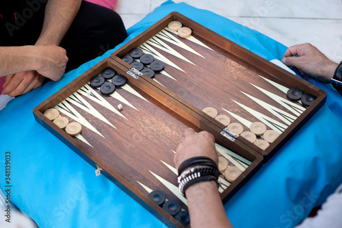 Two friends playing backgammon at home