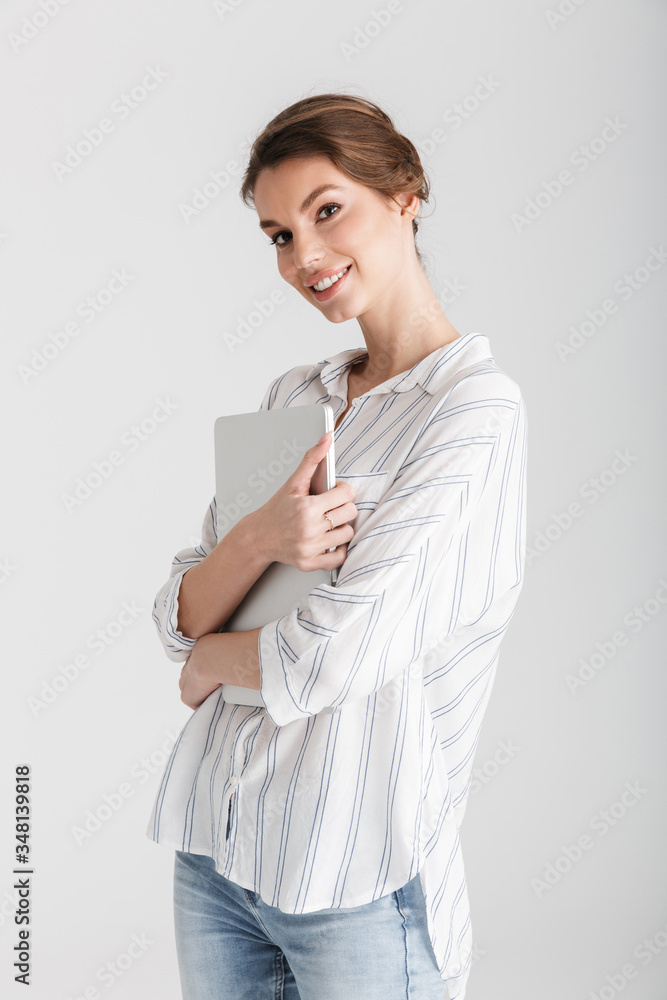 Image of joyful caucasian woman smiling and holding laptop Image of joyful caucasian woman smiling and holding laptop