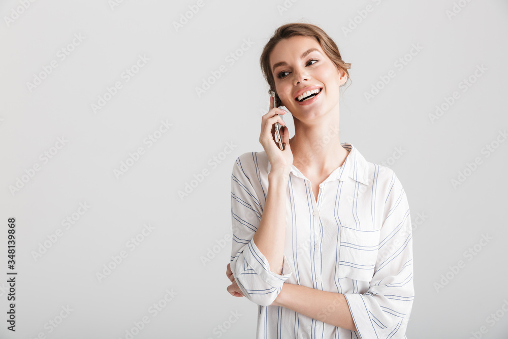 Image of joyful beautiful woman laughing and talking on cellphone Image of joyful beautiful woman laughing and talking on cellphone