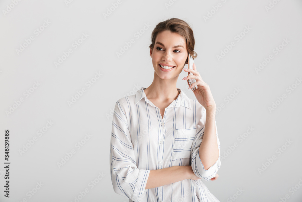 Image of joyful beautiful woman smiling and talking on cellphone Image of joyful beautiful woman smiling and talking on cellphone