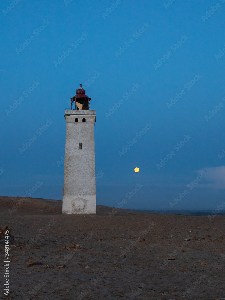 lighthouse with full moon on the coast of the sea