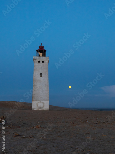 lighthouse with full moon on the coast of the sea