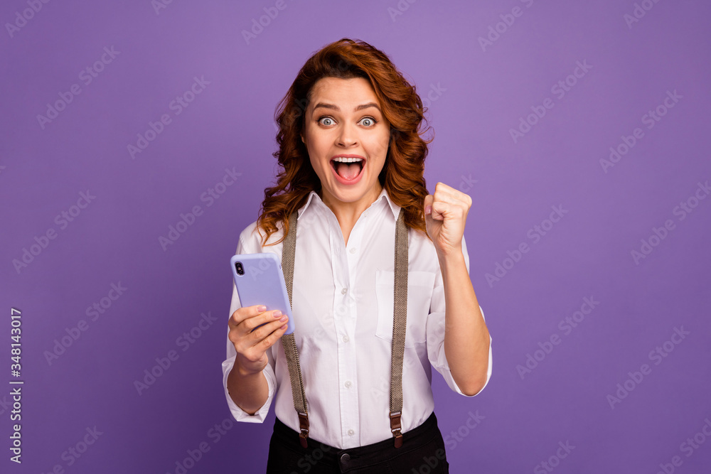 Photo of pretty funny crazy lady addicted casino player hold telephone raise fist set online bets poker win money internet game wear white shirt suspenders isolated purple color background Photo of pretty funny crazy lady addicted casino player hold telephone raise fist set online bets poker win money internet game wear white shirt suspenders isolated purple color background