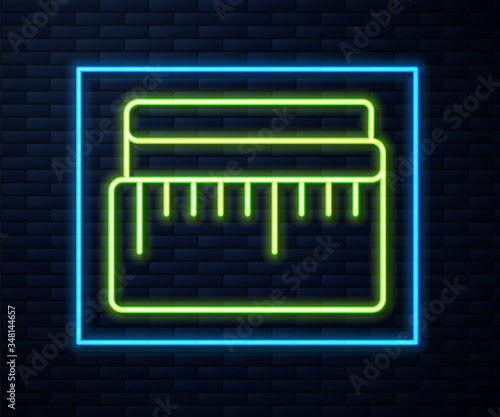 Glowing neon line Tape measure icon isolated on brick wall background. Measuring tape. Vector