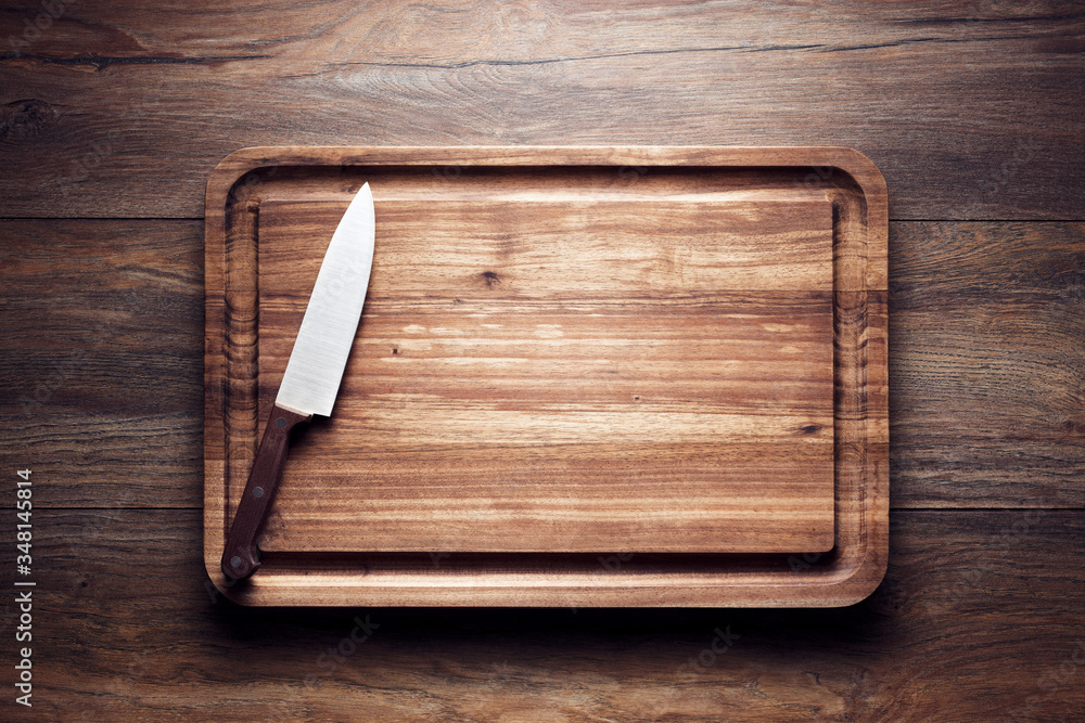 Vintage wooden cutting board with knife on wooden table - obrazy, fototapety, plakaty 