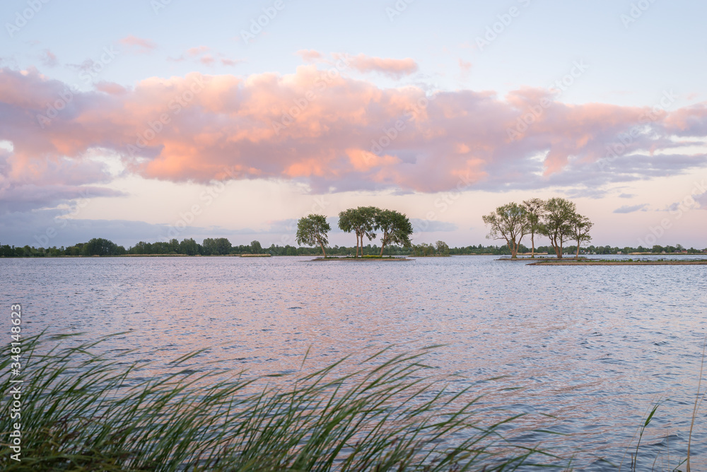 Beautiful landscape image of pink clouds over a lake in The Netherlands