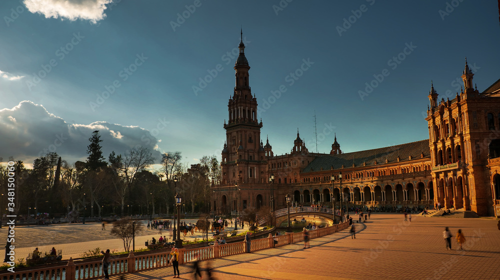Fototapeta premium Seville, Spain - February 20th, 2020 - North Tower of the Plaza de Espana / Spain Square with Horse Carriages and Tourists Strolling in Seville City Center.