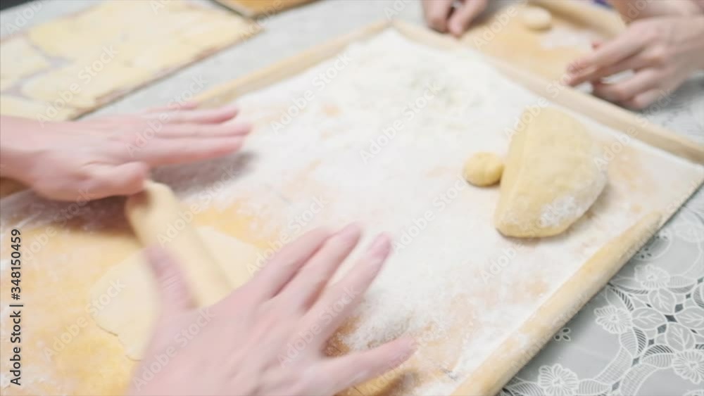 Family cooking. Mother sits on the kitchen with the baby and teach her how to kneed the dough. Family cooking. Mother sits on the kitchen with the baby and teach her how to kneed the dough.