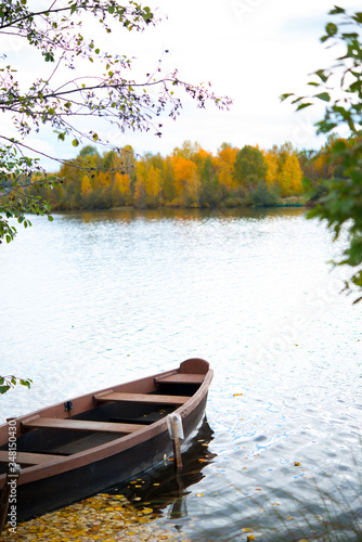Wooden boat in the pond in the autumn Park, autumn landscape, Golden autumn