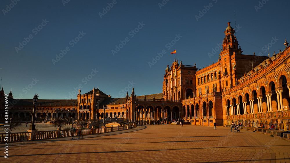 Seville, Spain - February 18th, 2020 - Tourists strolling in Plaza de Espana with beautiful Architecture Details at sunset in Seville City Center.