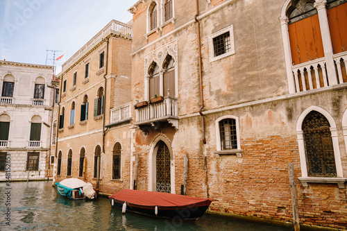 Canals in Venice, Italy. Boats moored in front of the houses, narrow canal in Venice, Italy during the day with historical buildings