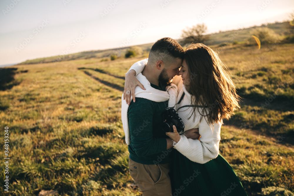 A guy and a girl love each other, smile, hug, kiss, laugh, enjoy life in the forest on a cliff, in the grass. Girl holding a film camera in her hands, photographs a guy, sunset in the background.
A guy and a girl love each other, smile, hug, kiss, laugh, enjoy life in the forest on a cliff, in the grass. Girl holding a film camera in her hands, photographs a guy, sunset in the background.