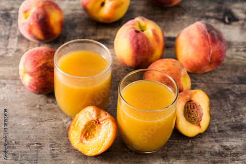 Natural peach juice in glass on wooden table	
