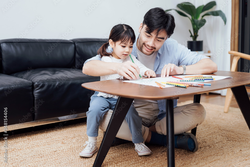 A pair of father and daughter drawing together A pair of father and daughter drawing together