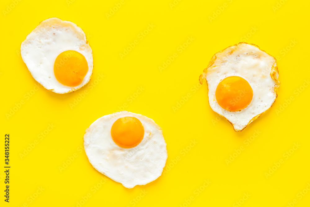 Fried eggs on yellow background top view Fried eggs on yellow background top view