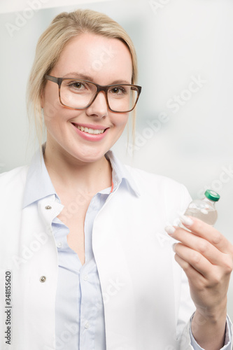female doctor is presenting a serum bottle