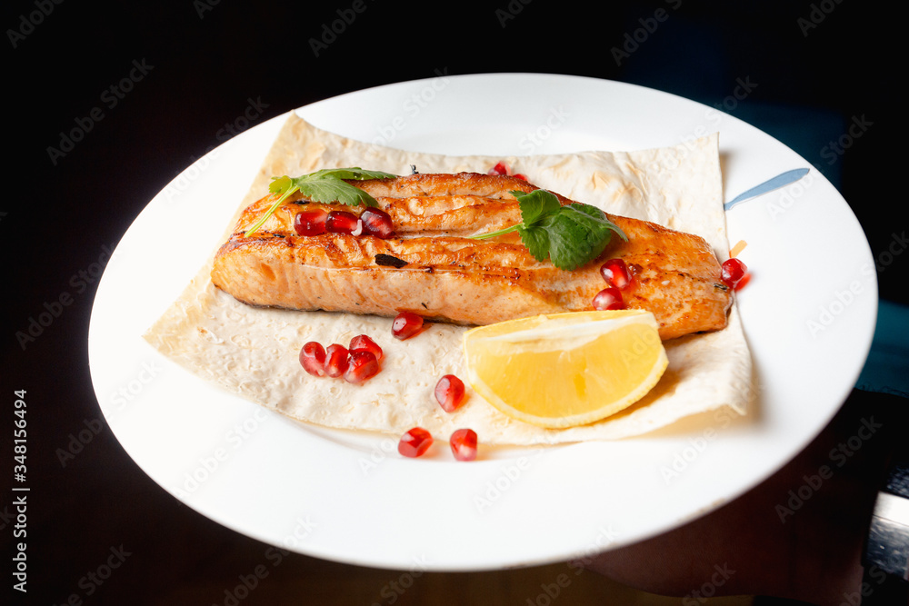 Grilled salmon steak served on pita bread Grilled salmon steak served on pita bread