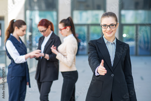 Portrait of a young and successful business woman who holds out her hand