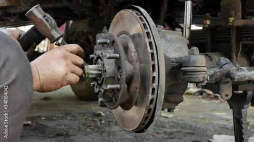 Technicians are removing the right front wheel hub of the car for replacement and repair.