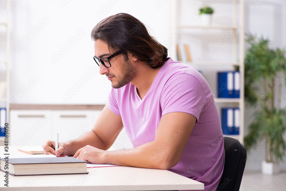 Young male student preparing for exams at classroom Young male student preparing for exams at classroom